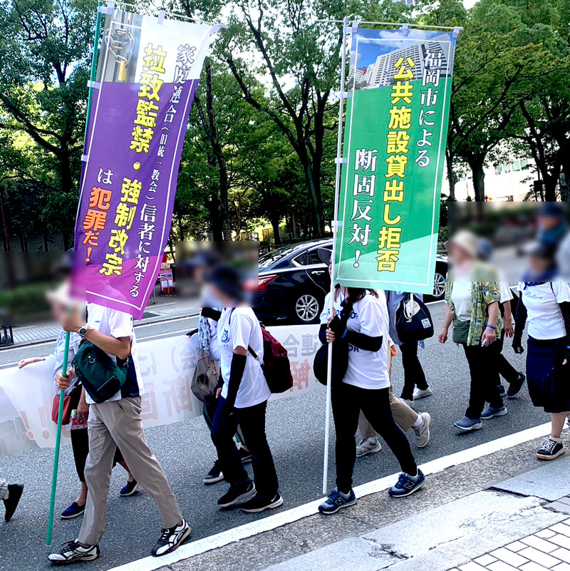 福岡市に抗議するのぼりを掲げる信徒